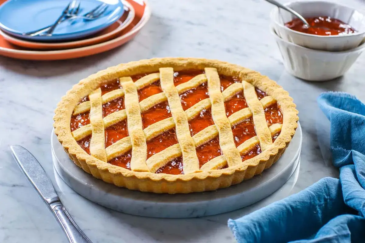 Una deliziosa crostata di marmellata con una griglia dorata di pasta frolla, pronta per essere gustata.