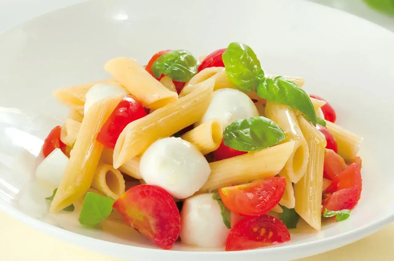 Penne con pomodorini, mozzarelline e basilico fresco, un'esplosione di sapori per la tua pasta alla crudaiola.