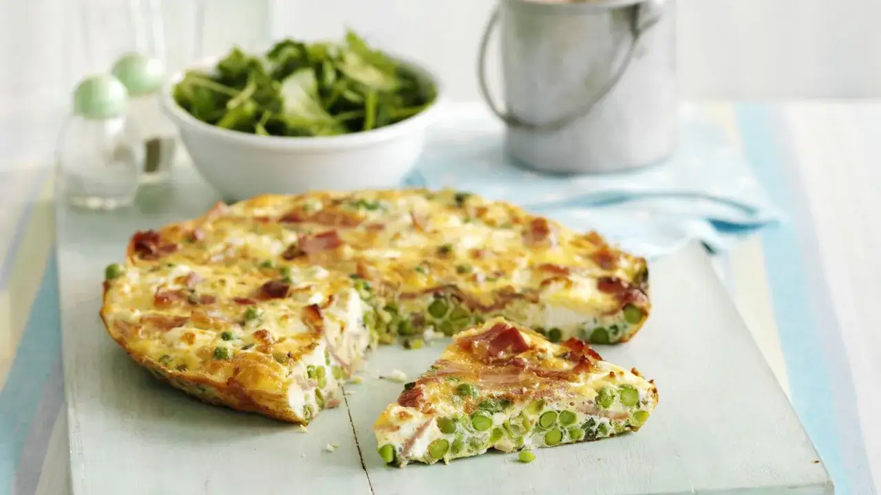 Una fetta di frittata di piselli e pancetta, soffice e dorata, pronta per essere gustata.