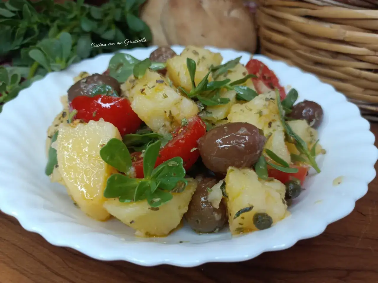 Deliziosa insalata di patate con pomodorini, olive e erbe fresche, un piatto estivo perfetto.