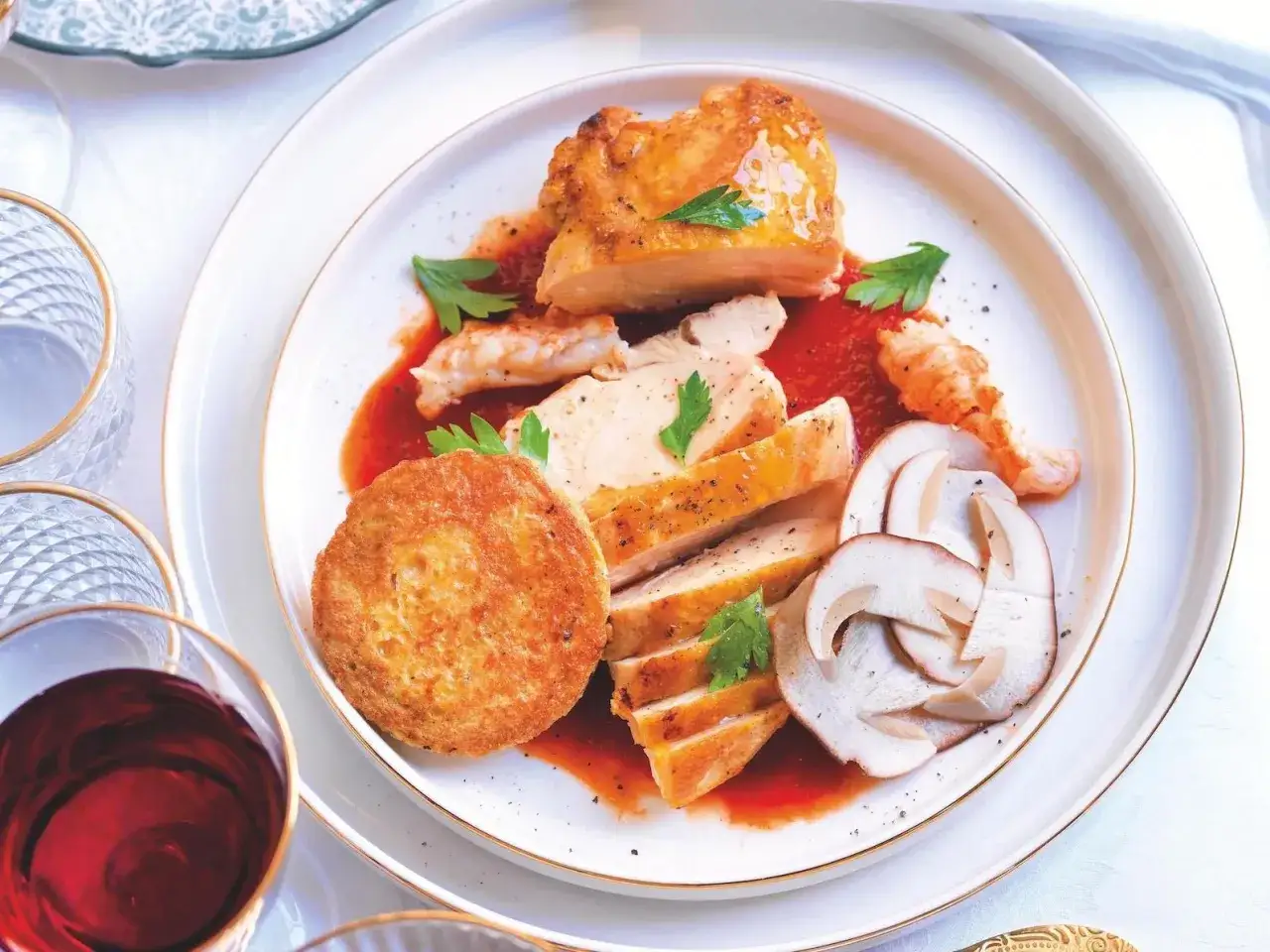 Un invitante pollo alla marengo, con petto affettato, gamberi, funghi e una croccante tortino, il tutto su un letto di salsa rossa.