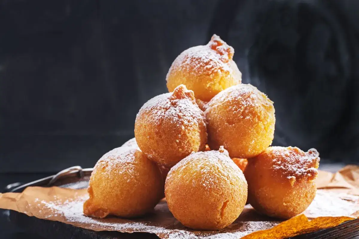 Saporite sfinci siciliani ricetta originale, dorate e cosparse di zucchero a velo, pronte per essere gustate.