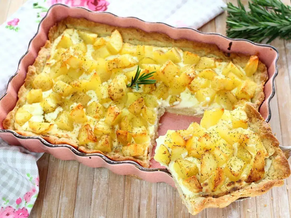 Torta salata con patate dorate e rosmarino, una fetta appena tolta dal forno.