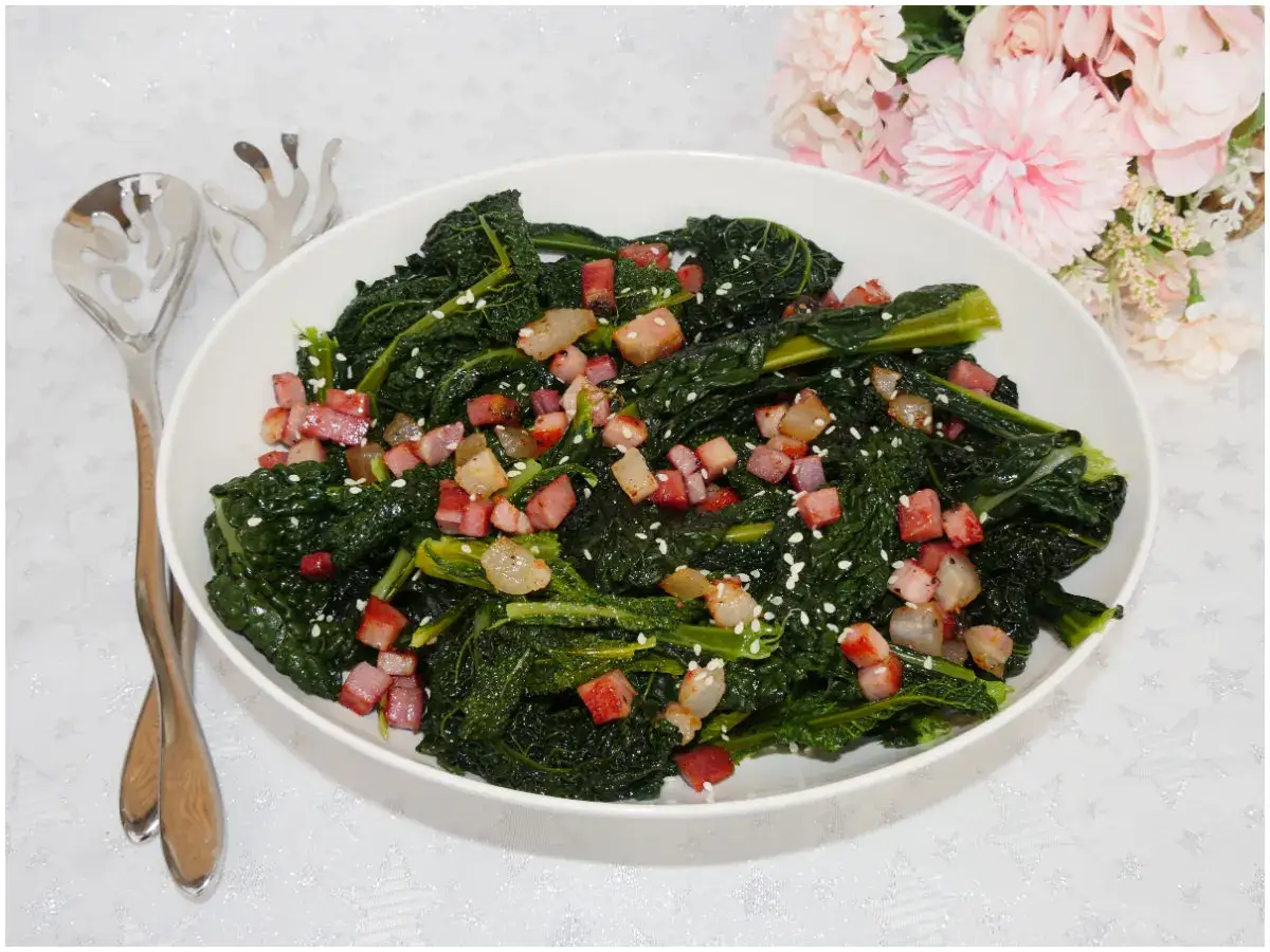 Cavolo nero ricetta: un contorno saporito con cubetti di pancetta croccante e semi di sesamo.