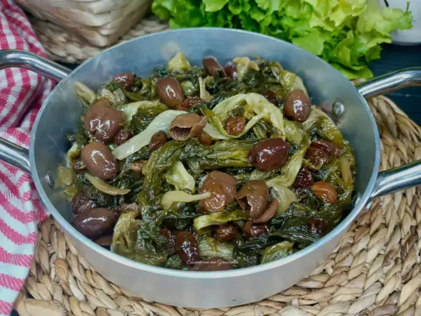 Scarola in padella con olive e uvetta, un contorno saporito e colorato, pronto per essere gustato.