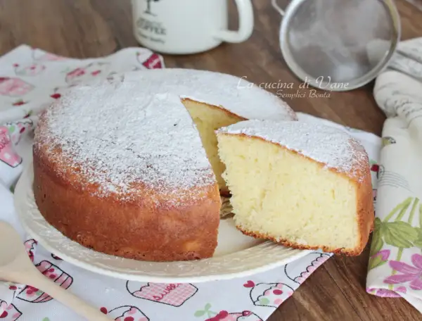 Una soffice torta yogurt greco, spolverata di zucchero a velo, pronta per essere gustata.
