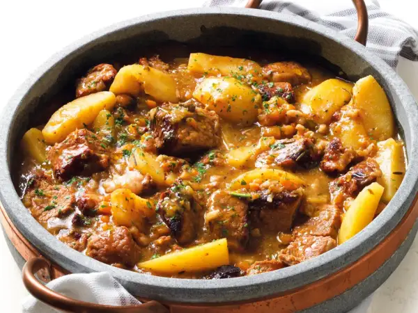 Un invitante spezzatino di manzo morbidissimo con patate, cotto lentamente in un ricco sugo e guarnito con prezzemolo fresco.