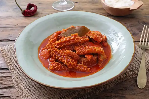 Un piatto fumante di trippa alla fiorentina, con la sua consistenza unica e il sugo rosso invitante, pronto per essere gustato.