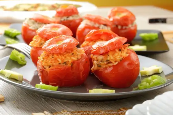 Pomodori ripieni di riso, un piatto colorato e saporito, con peperoni verdi e zucchine a guarnire.