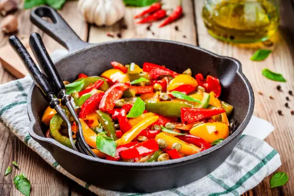 Peperoni in padella, colorati e succosi, pronti per essere gustati. Un contorno semplice e saporito.